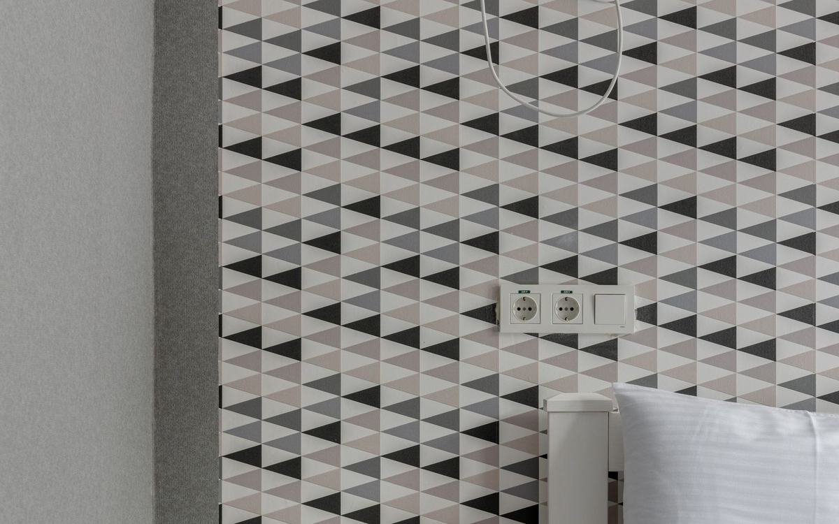 Patterned wallpaper hung on a bedroom feature wall